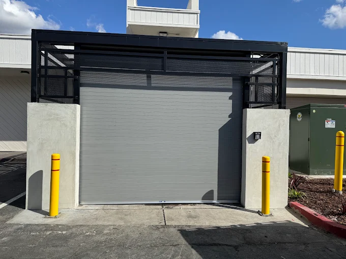 Commercial roll-up door with security grille enclosure