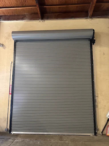 Gray commercial rolling steel door installed in a warehouse opening