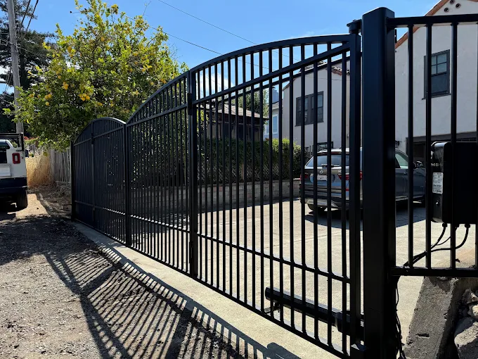 Black wrought iron automatic slide gate at a residential driveway