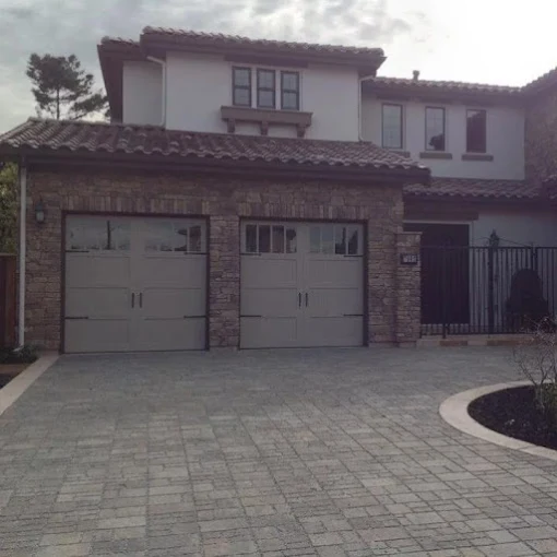 Stone and stucco home with two matching carriage-style garage doors